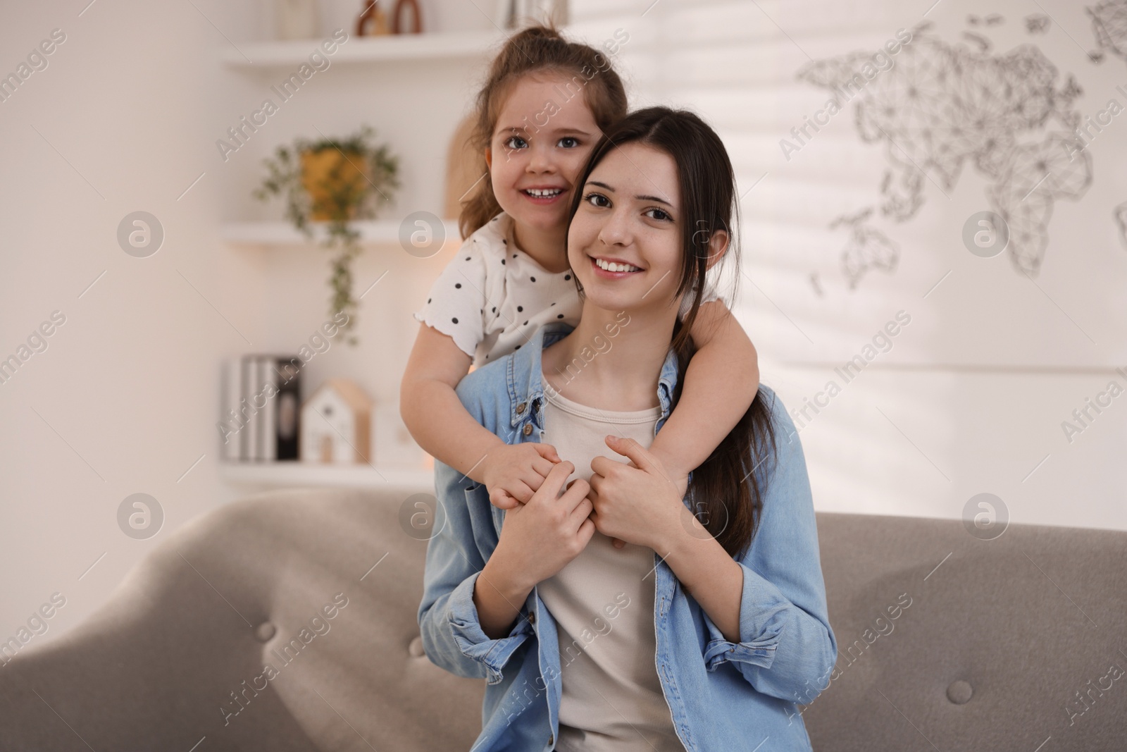 Photo of Portrait of cute little girl and her sister indoors