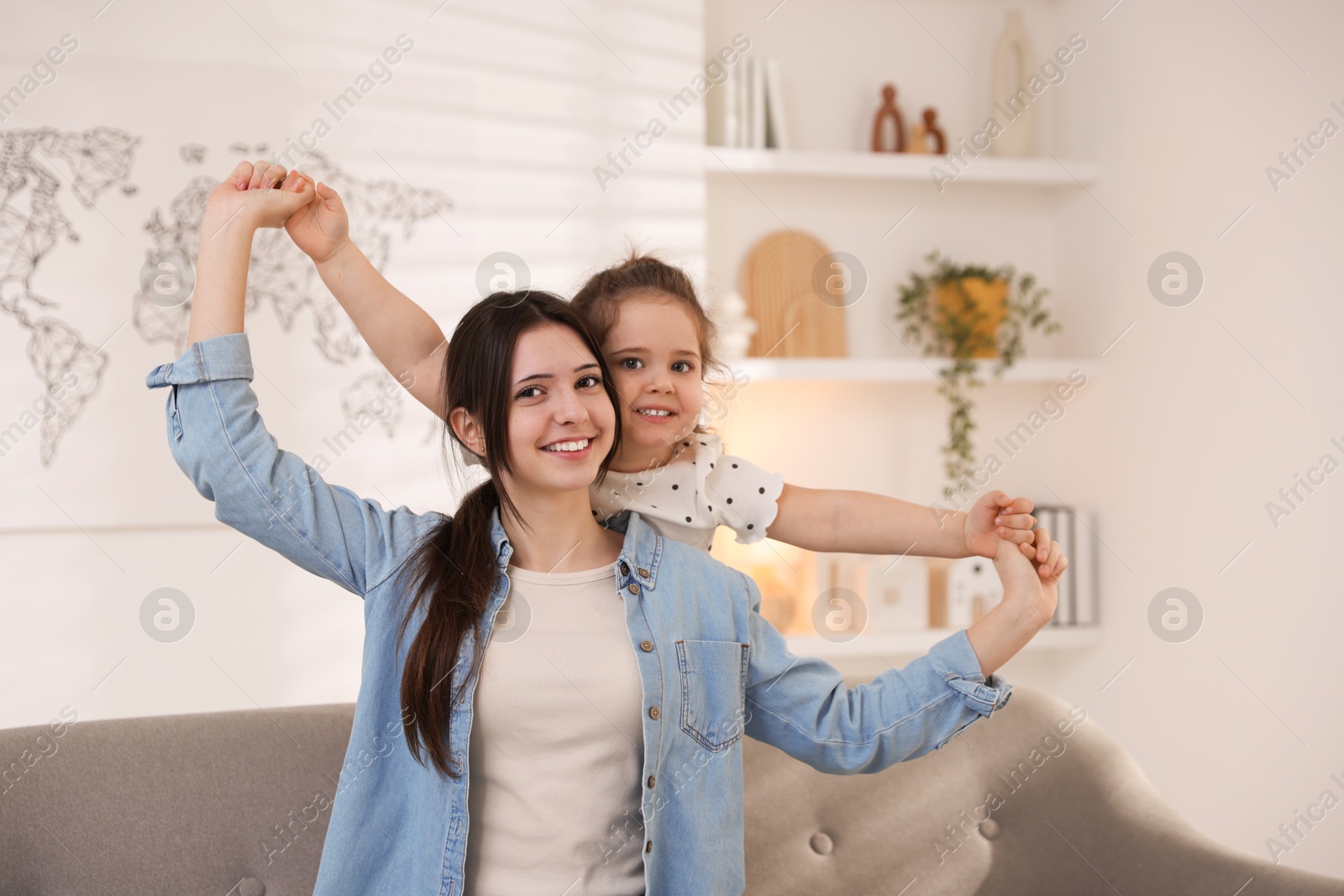 Photo of Portrait of cute little girl and her sister indoors