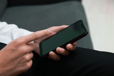 Photo of Man using smartphone with blank screen indoors, closeup