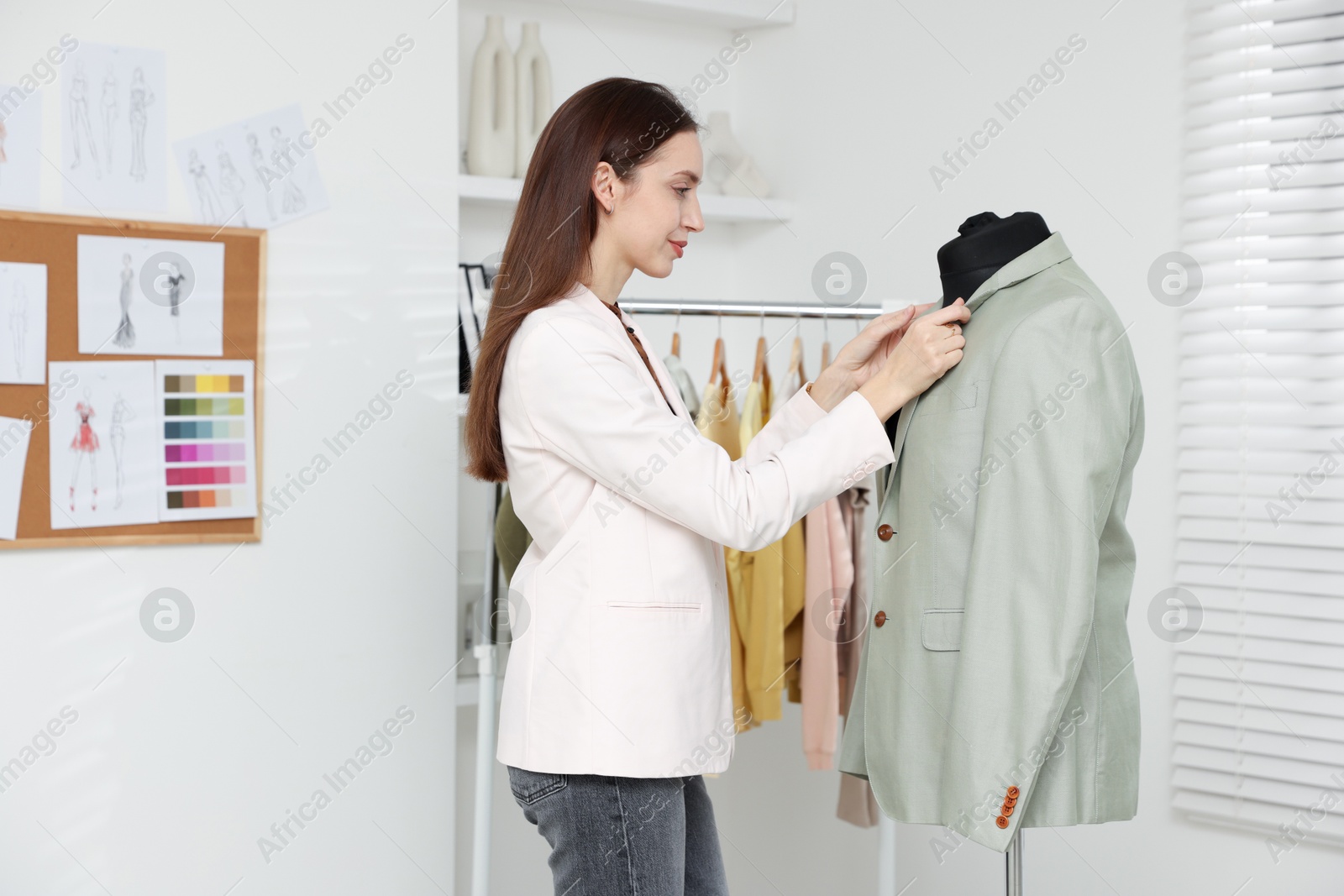 Photo of Fashion designer working with jacket in workshop