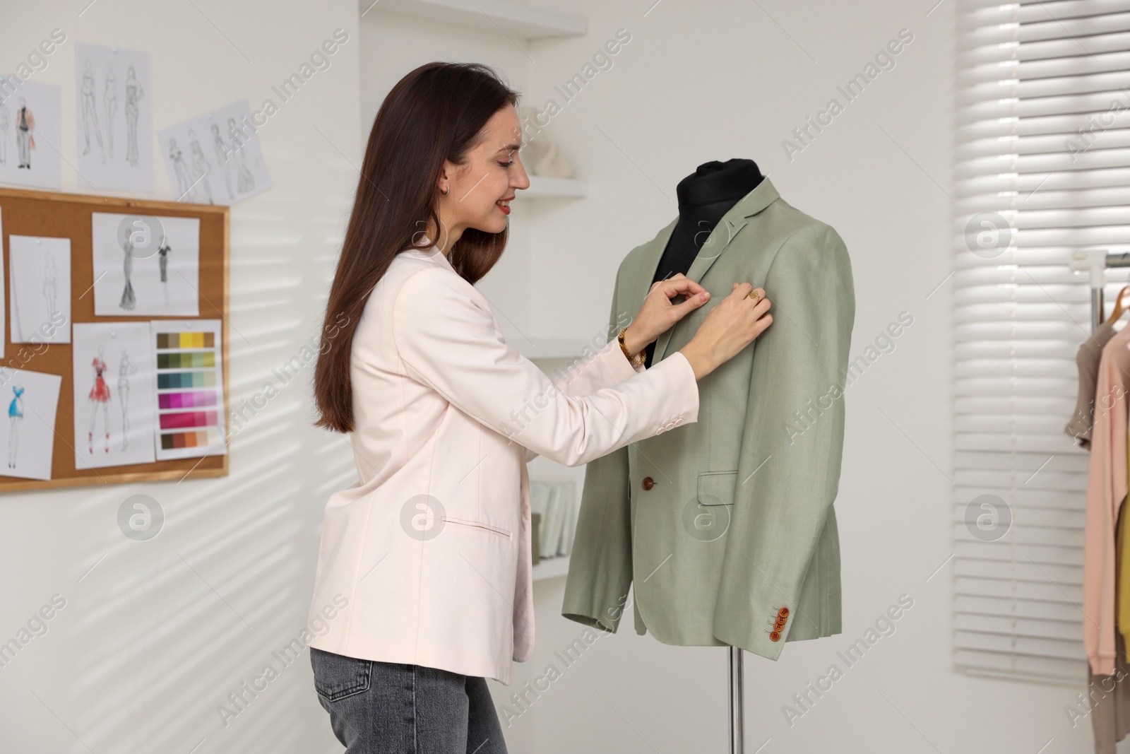 Photo of Fashion designer working with jacket in workshop