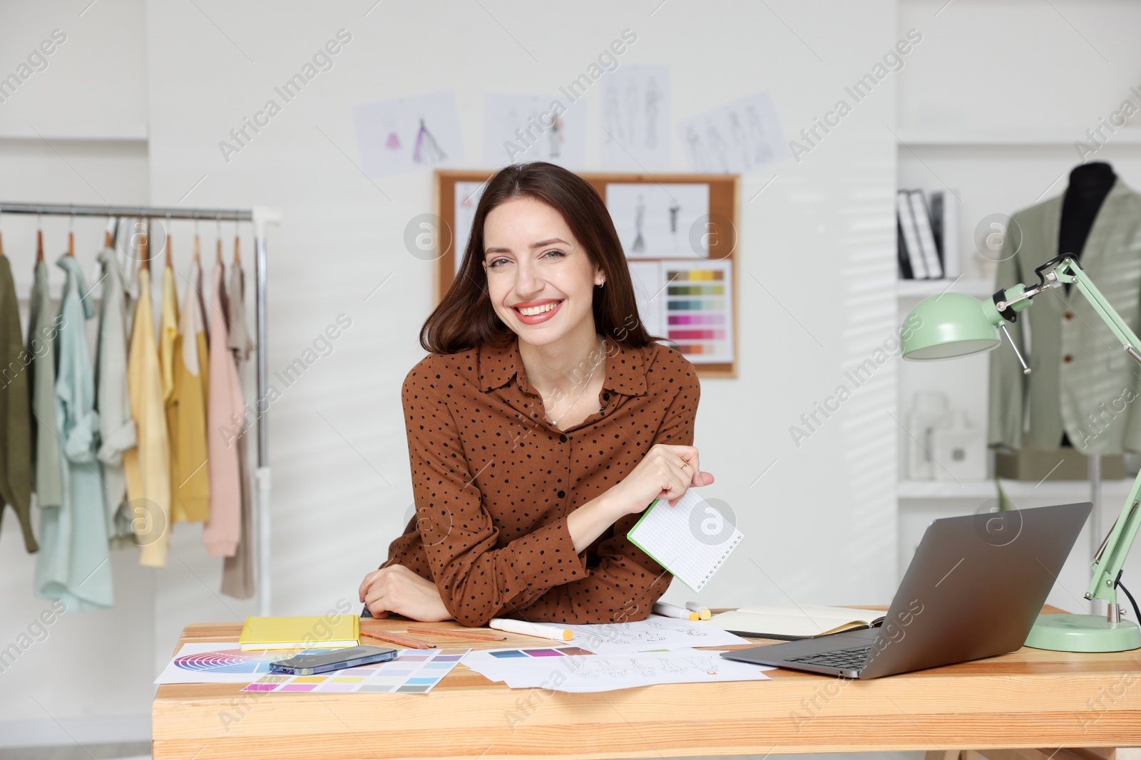 Photo of Fashion designer working at wooden table in workshop