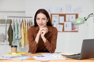 Photo of Fashion designer working at wooden table in workshop