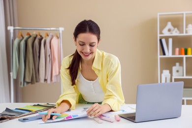 Photo of Fashion designer working at white table in workshop