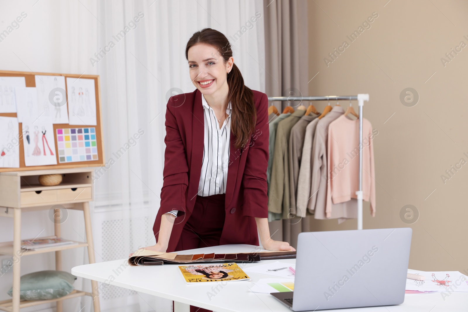 Photo of Fashion designer at white table in workshop