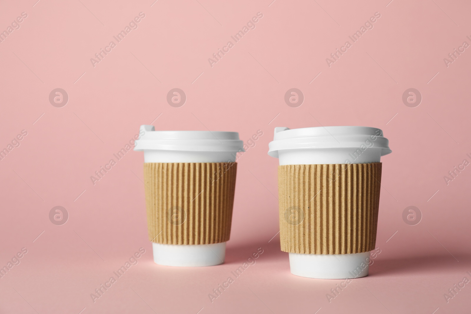 Paper cups on pink background. Mockup for design Photo of Paper cups on pink background. Mockup for design