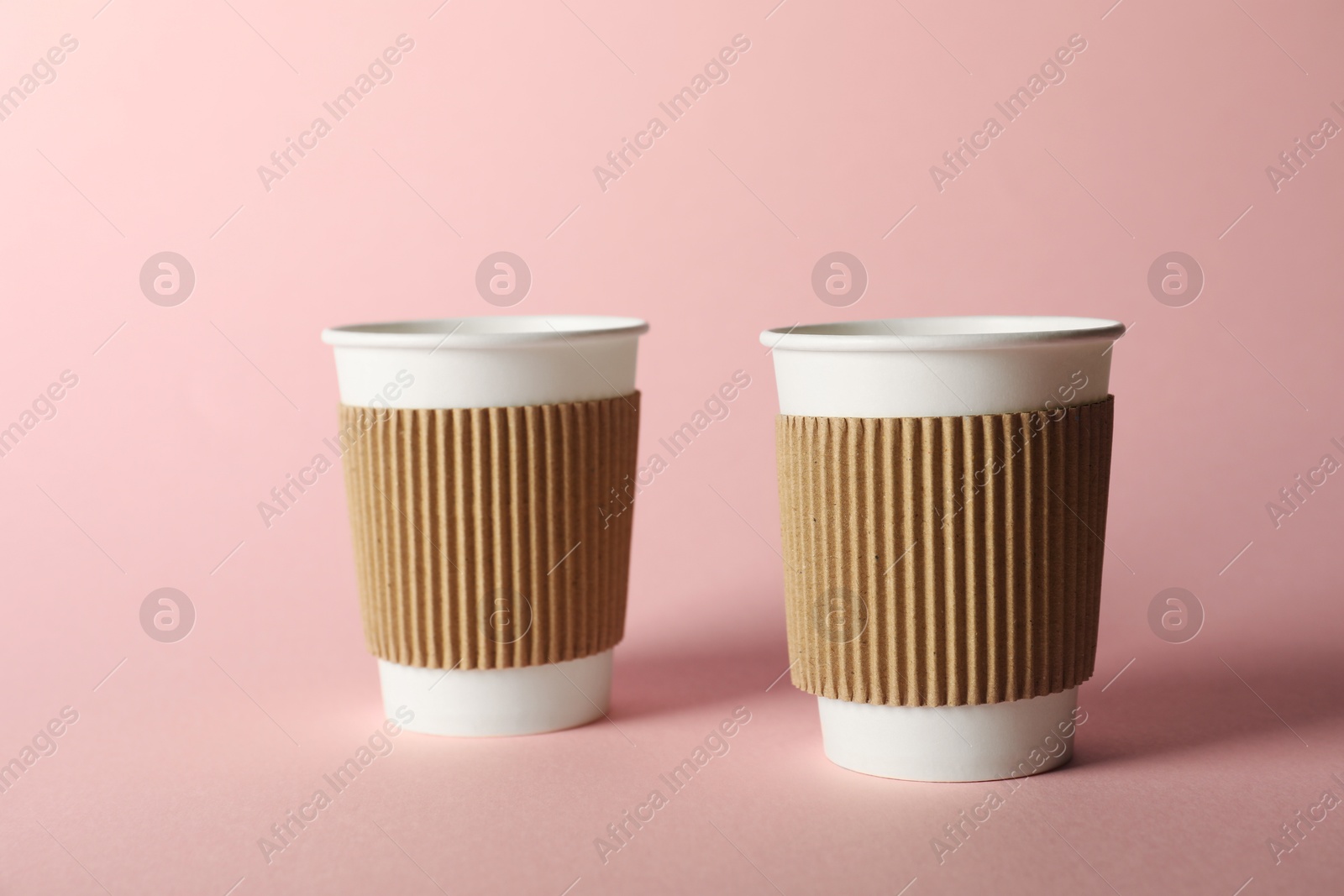 Paper cups on pink background. Mockup for design Photo of Paper cups on pink background. Mockup for design