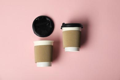 Photo of Paper cups with lids on pink background, flat lay. Mockup for design