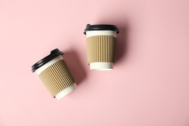 Photo of Paper cups with lids on pink background, flat lay. Mockup for design
