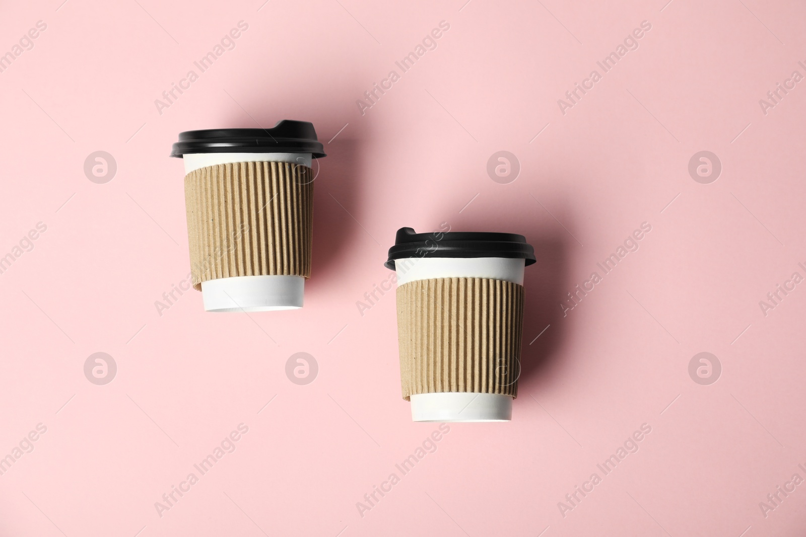 Paper cups with lids on pink background, flat lay. Mockup for design Photo of Paper cups with lids on pink background, flat lay. Mockup for design
