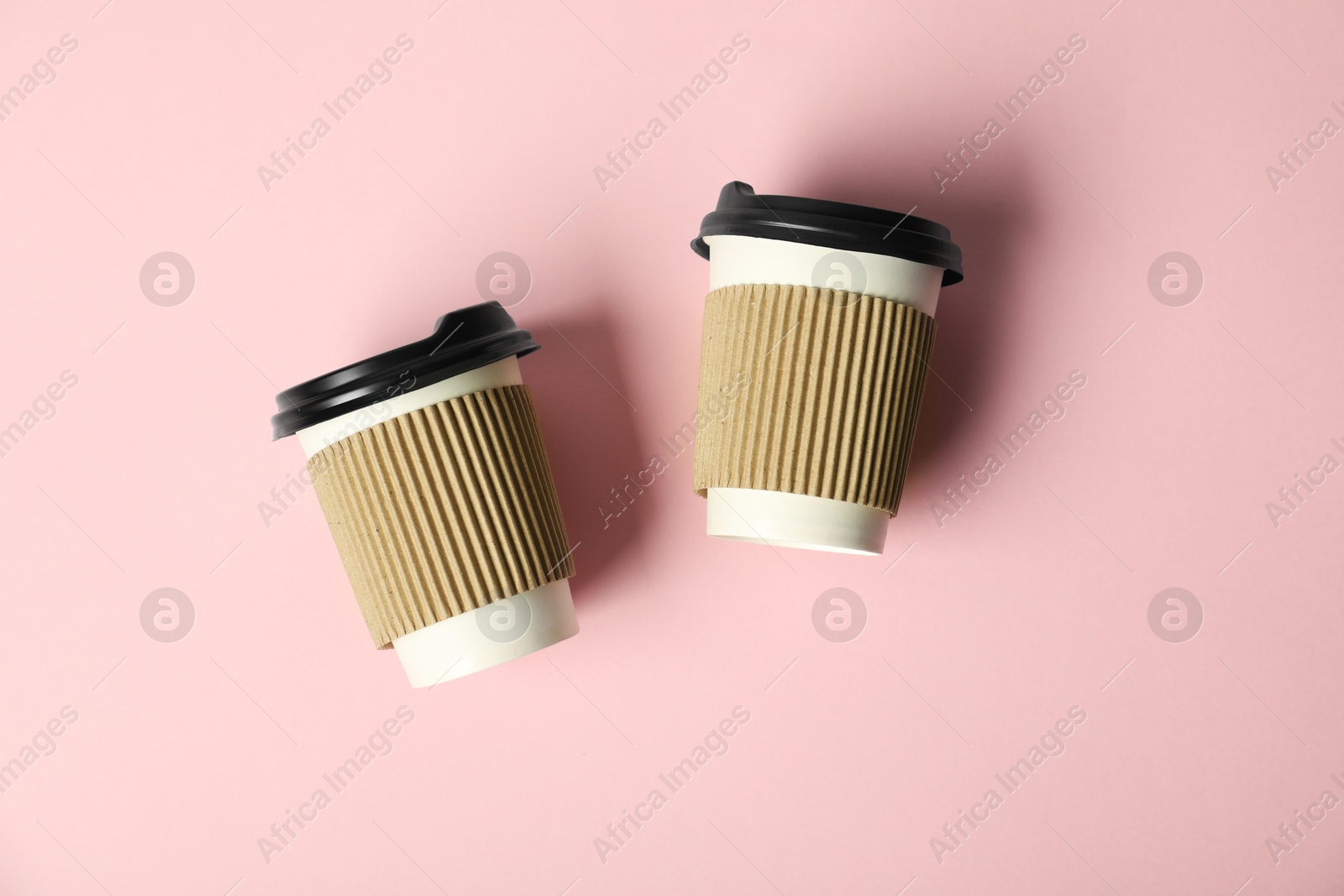Paper cups with lids on pink background, flat lay. Mockup for design Photo of Paper cups with lids on pink background, flat lay. Mockup for design