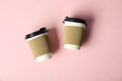 Photo of Paper cups with lids on pink background, flat lay. Mockup for design