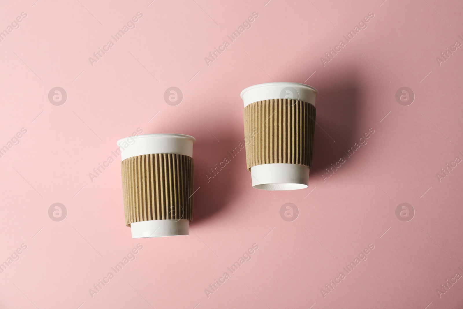 Paper cups on pink background, flat lay. Mockup for design Photo of Paper cups on pink background, flat lay. Mockup for design