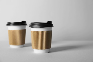 Photo of Paper cups with lids on grey background. Mockup for design