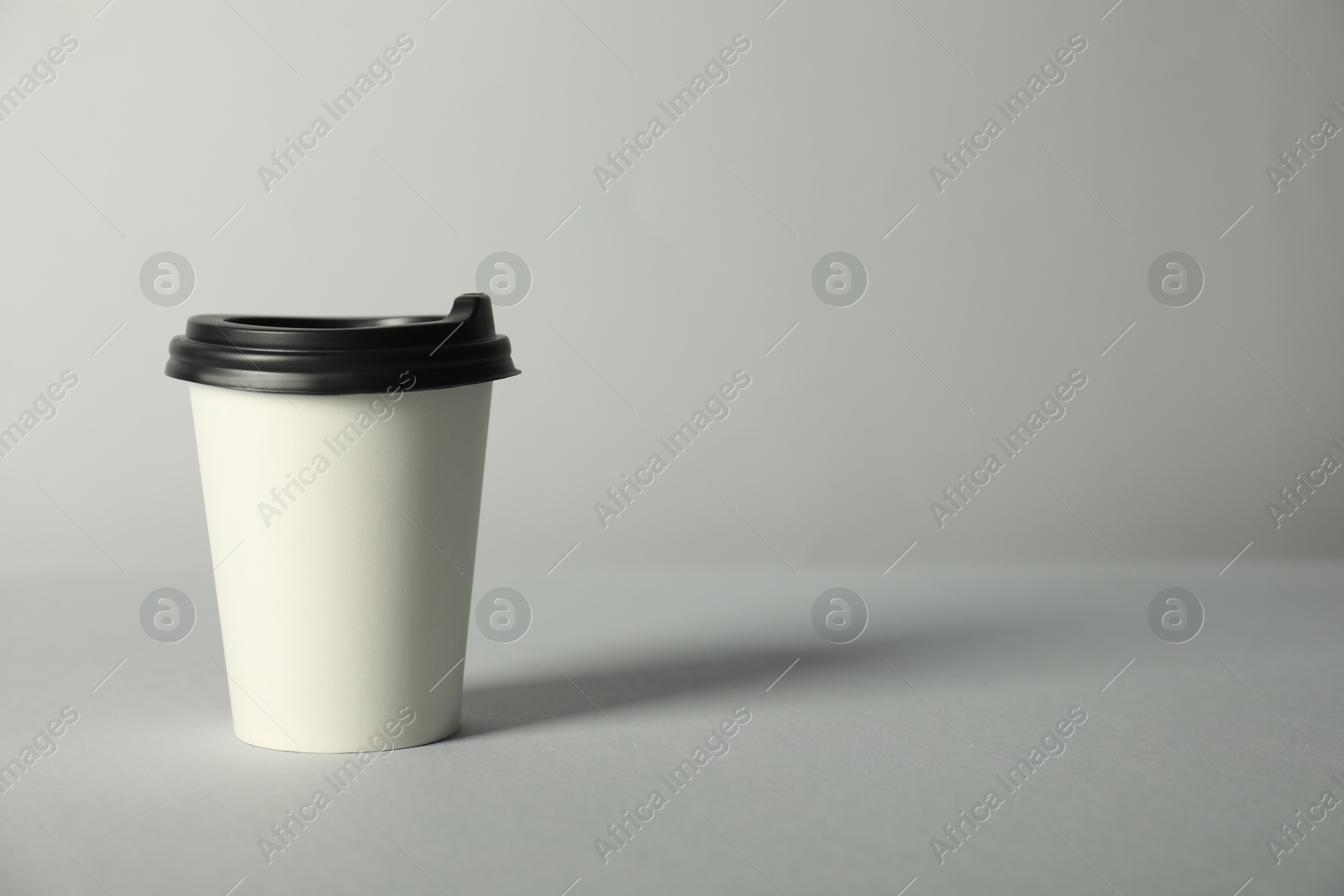 Paper cup with lid on grey background. Mockup for design Photo of Paper cup with lid on grey background. Mockup for design
