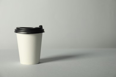 Photo of Paper cup with lid on grey background. Mockup for design