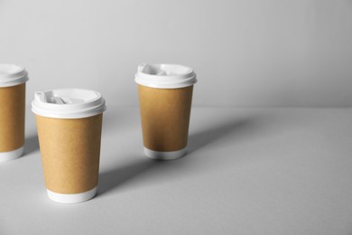 Photo of Paper cups with lids on grey background. Mockup for design