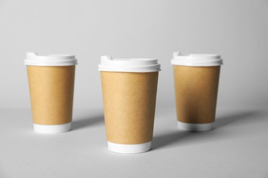 Photo of Paper cups with lids on grey background. Mockup for design