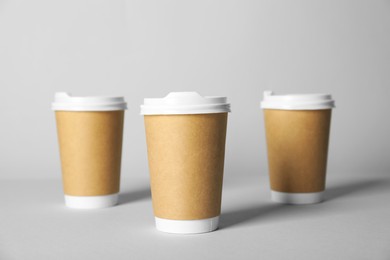 Photo of Paper cups with lids on grey background, selective focus. Mockup for design