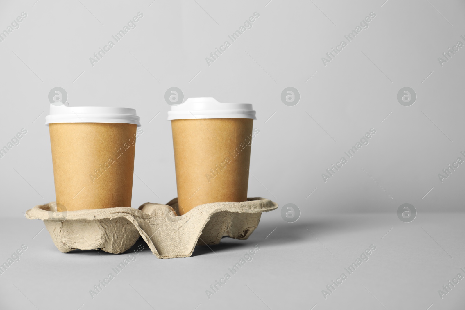 Paper cups with lids on grey background. Mockup for design Photo of Paper cups with lids on grey background. Mockup for design