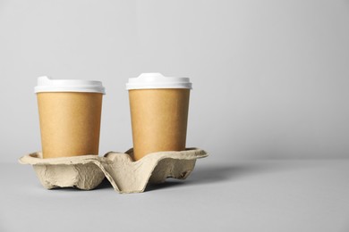 Photo of Paper cups with lids on grey background. Mockup for design