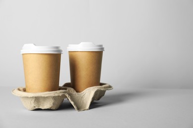 Photo of Paper cups with lids on grey background. Mockup for design