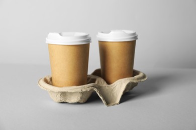 Photo of Paper cups with lids on grey background, closeup. Mockup for design