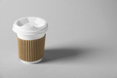 Photo of Paper cup with lid on grey background. Mockup for design