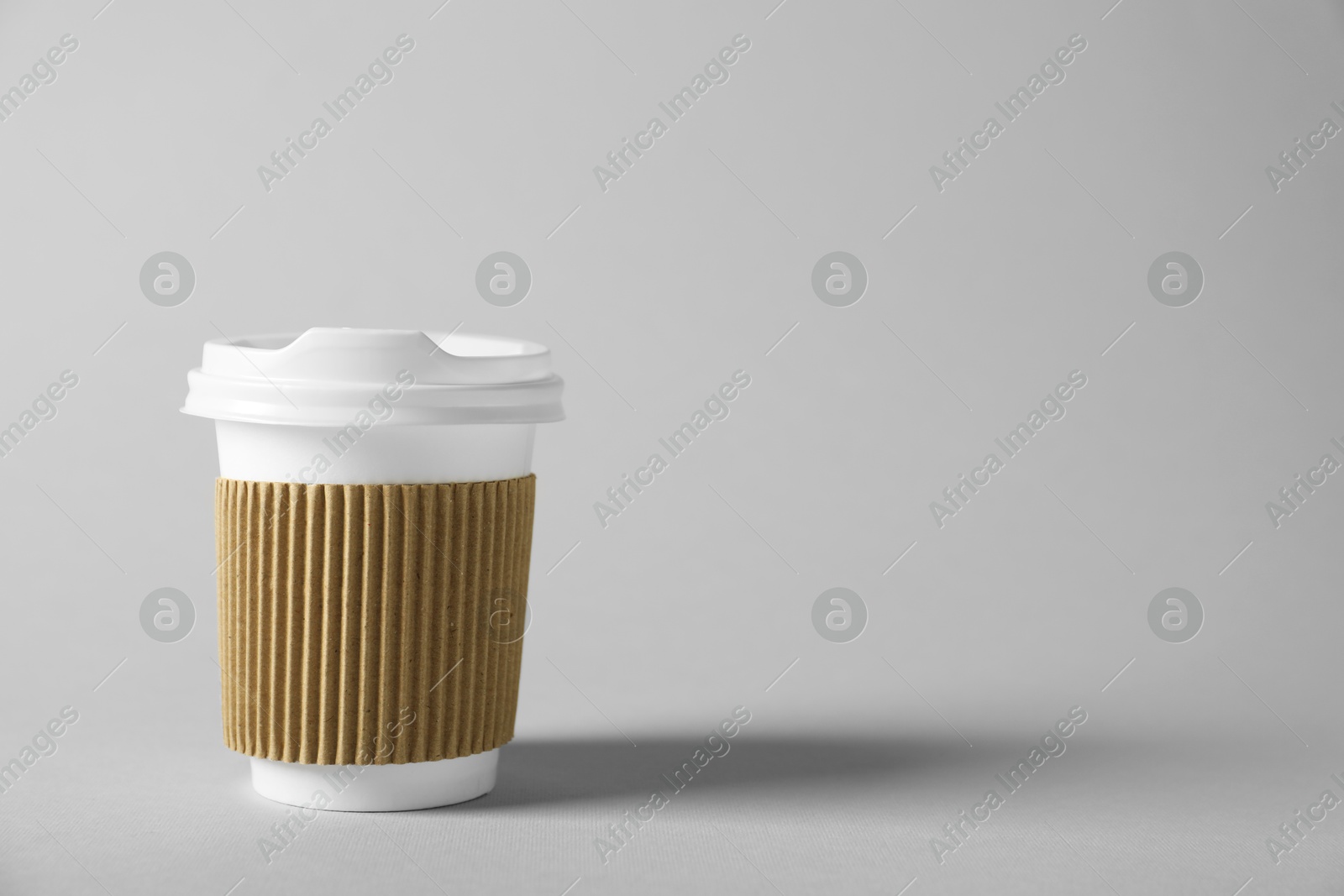 Paper cup with lid on grey background. Mockup for design Photo of Paper cup with lid on grey background. Mockup for design