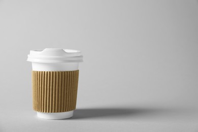 Photo of Paper cup with lid on grey background. Mockup for design