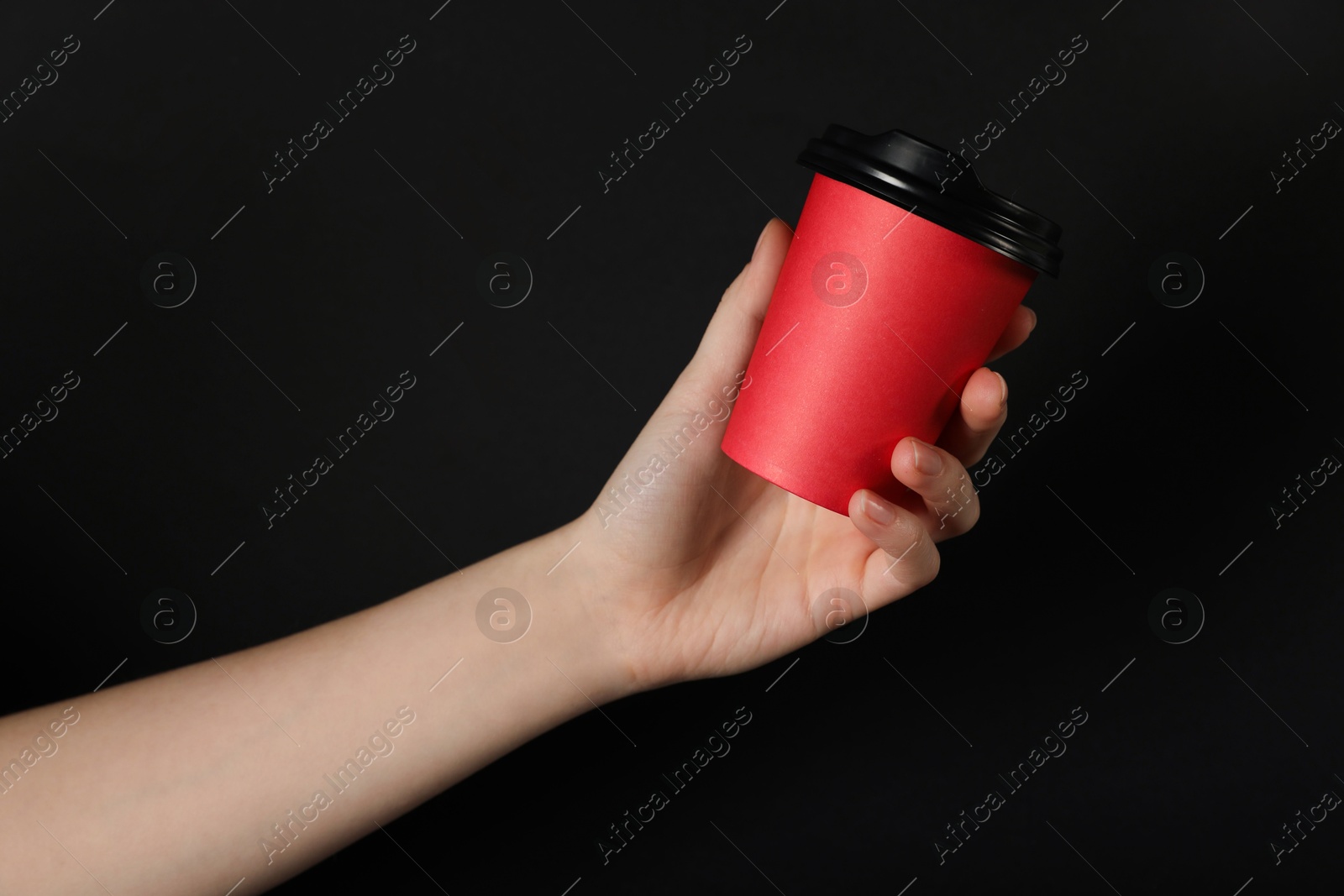Woman holding paper cup on black background, closeup. Mockup for design Photo of Woman holding paper cup on black background, closeup. Mockup for design