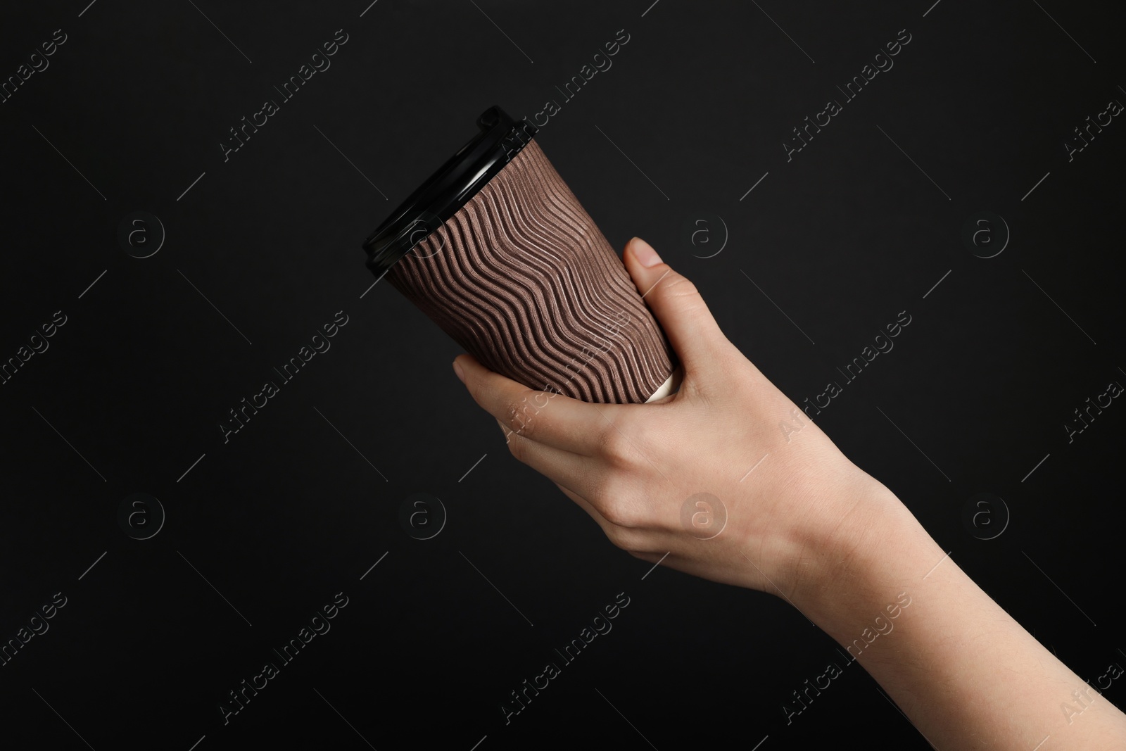 Woman holding paper cup on black background, closeup. Mockup for design Photo of Woman holding paper cup on black background, closeup. Mockup for design