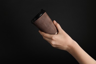 Photo of Woman holding paper cup on black background, closeup. Mockup for design