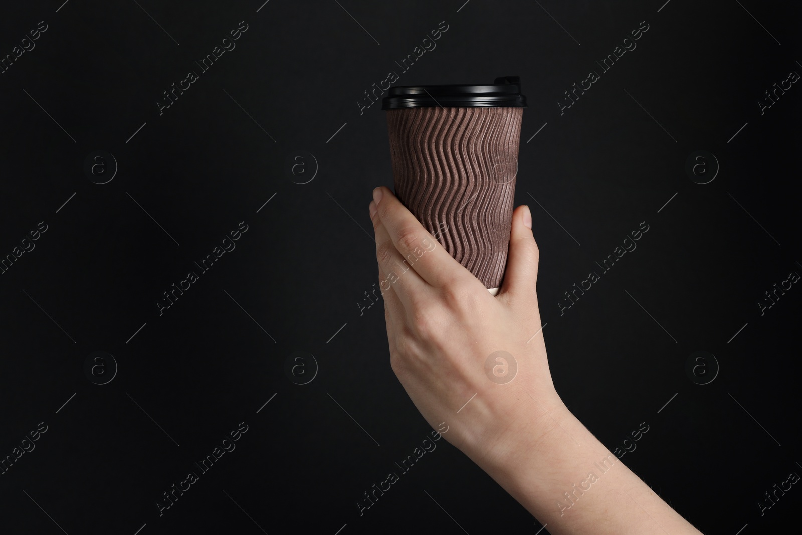 Woman holding paper cup on black background, closeup. Mockup for design Photo of Woman holding paper cup on black background, closeup. Mockup for design