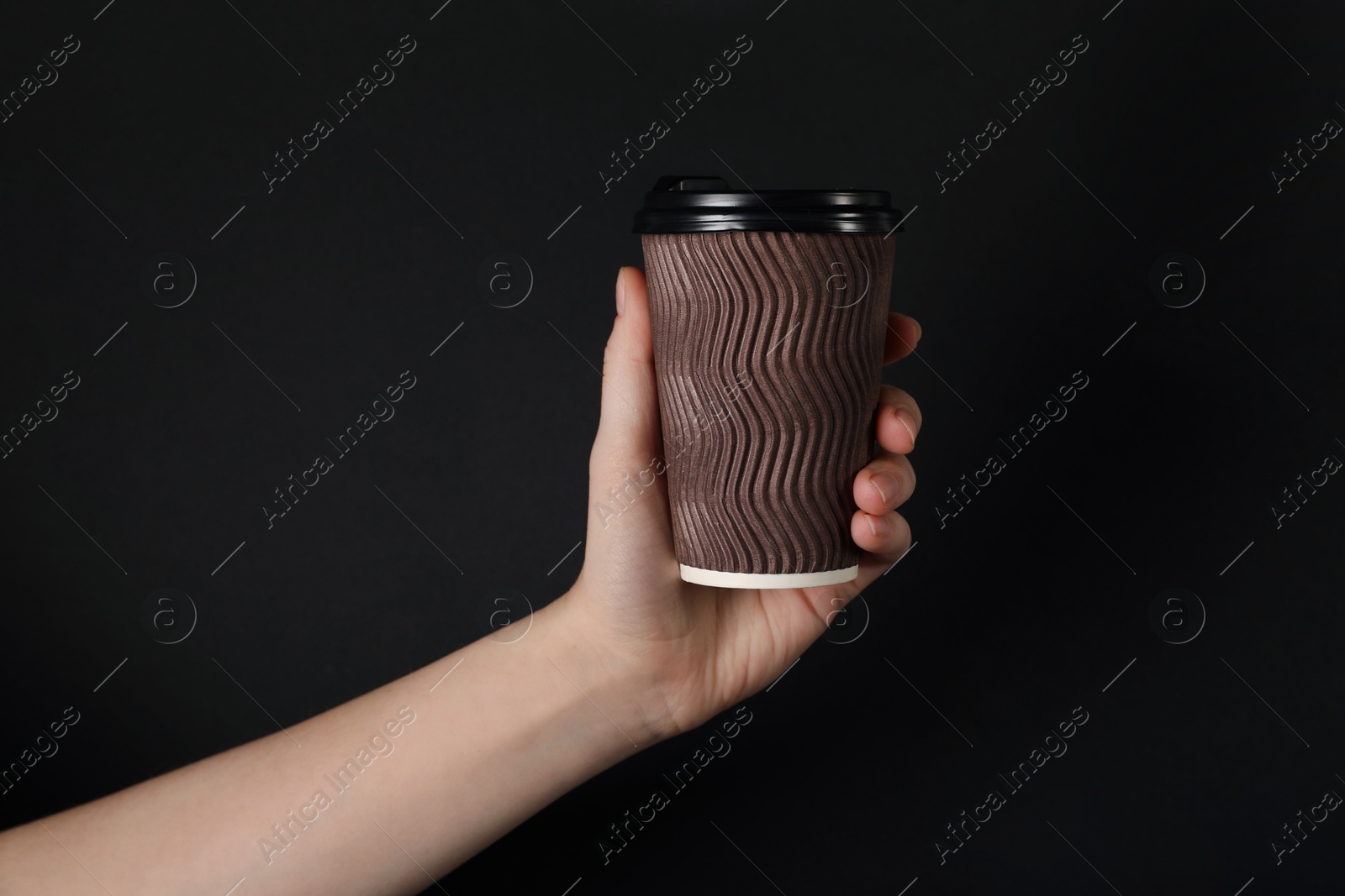 Woman holding paper cup on black background, closeup. Mockup for design Photo of Woman holding paper cup on black background, closeup. Mockup for design