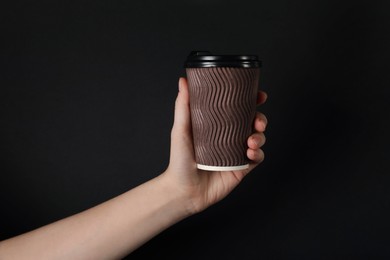 Photo of Woman holding paper cup on black background, closeup. Mockup for design