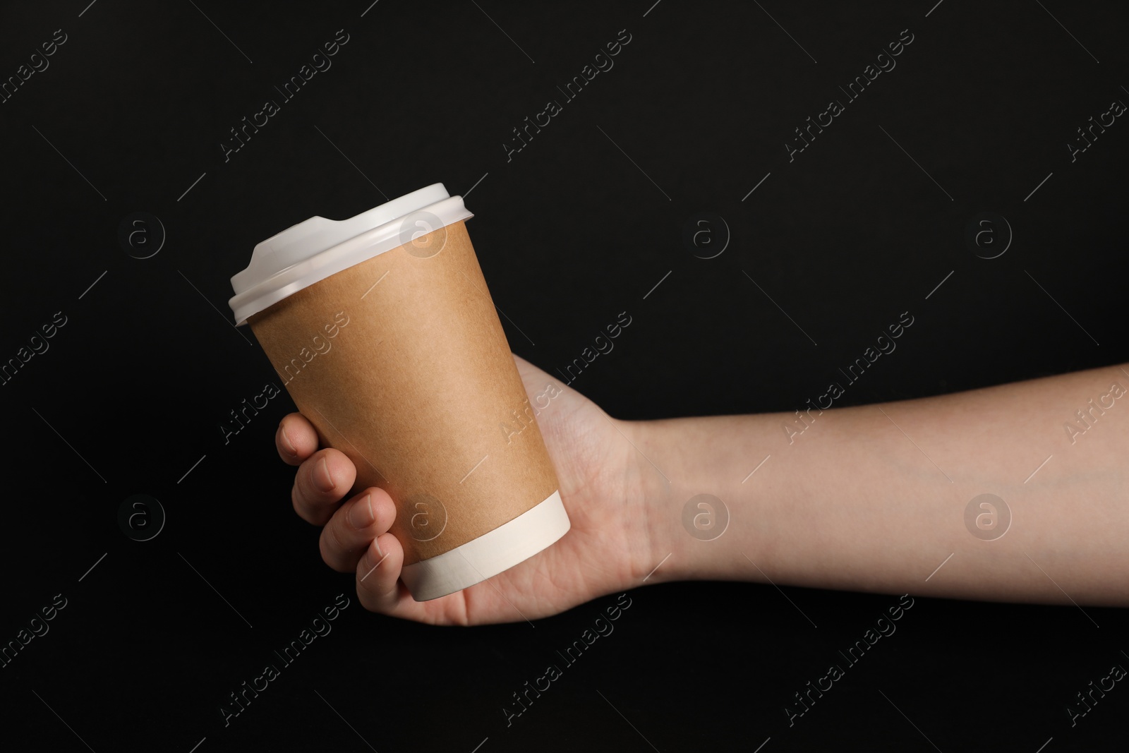 Woman holding paper cup on black background, closeup. Mockup for design Photo of Woman holding paper cup on black background, closeup. Mockup for design