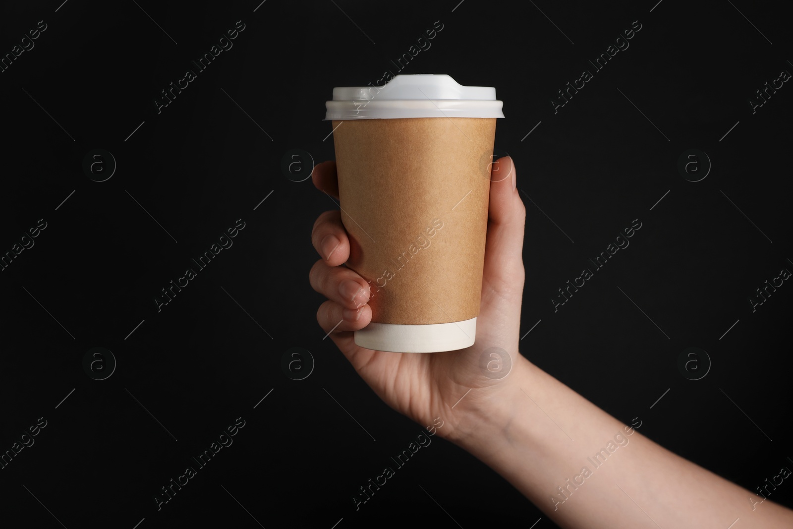 Woman holding paper cup on black background, closeup. Mockup for design Photo of Woman holding paper cup on black background, closeup. Mockup for design
