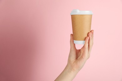 Photo of Woman holding paper cup on pink background, closeup. Mockup for design