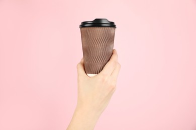 Photo of Woman holding paper cup on pink background, closeup. Mockup for design