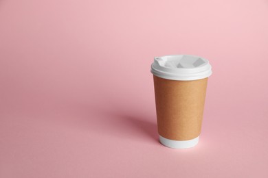 Photo of One paper cup on pink background. Mockup for design