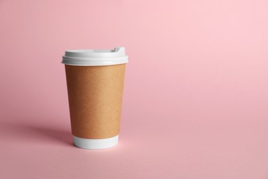 Photo of One paper cup on pink background. Mockup for design