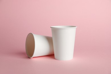 Photo of Paper cups on pink background. Mockup for design