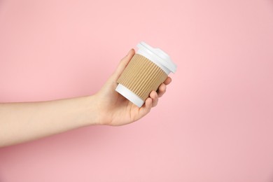 Photo of Woman holding paper cup on pink background, closeup. Mockup for design