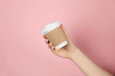 Photo of Woman holding paper cup on pink background, closeup. Mockup for design