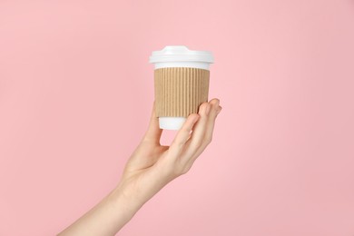 Photo of Woman holding paper cup on pink background, closeup. Mockup for design