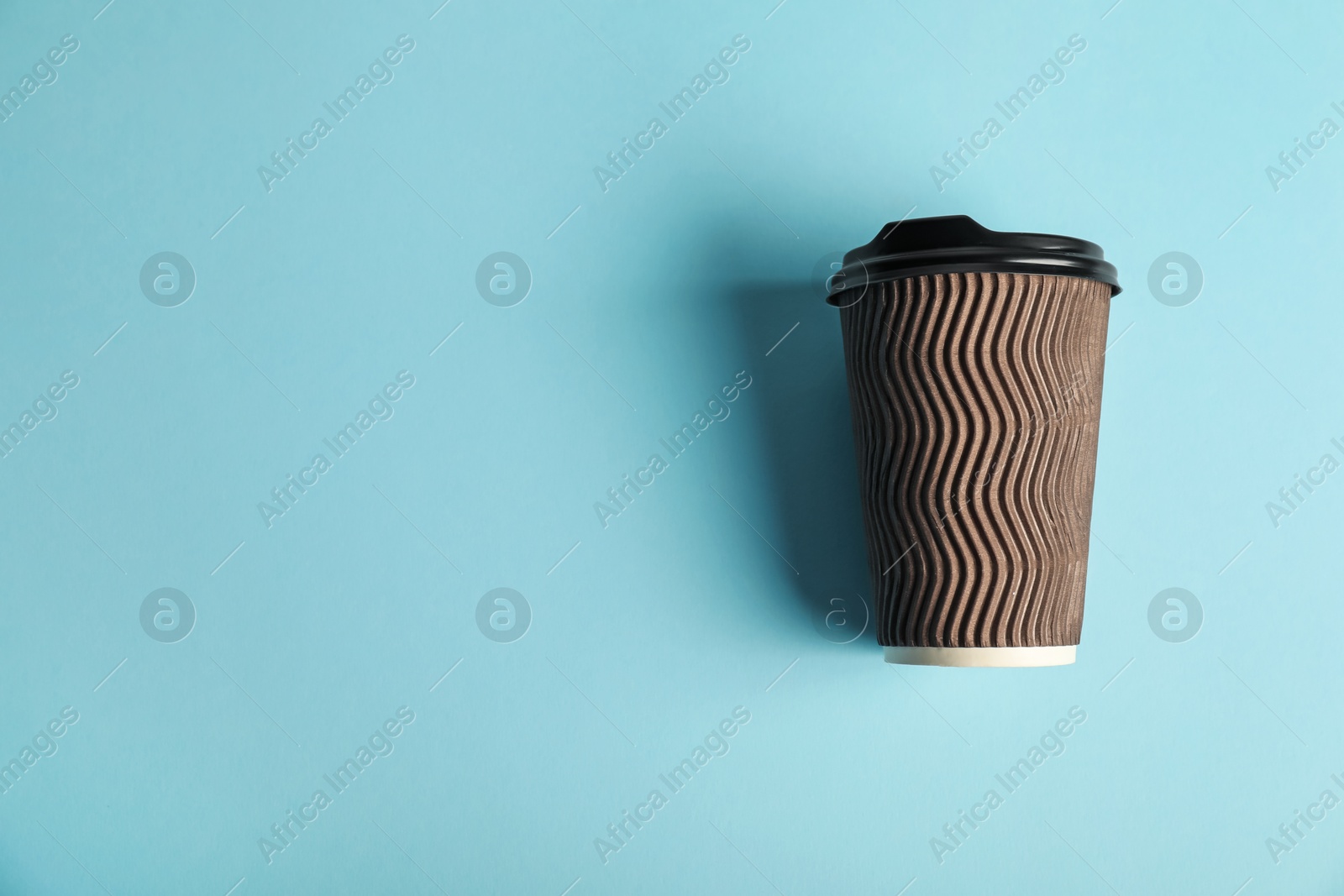 Paper cup on light blue background, top view. Mockup for design Photo of Paper cup on light blue background, top view. Mockup for design