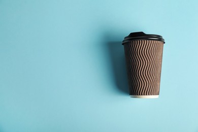 Photo of Paper cup on light blue background, top view. Mockup for design