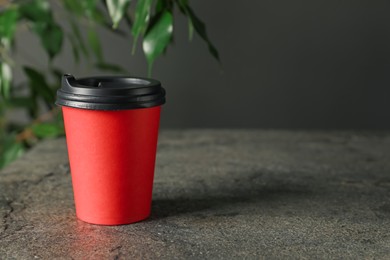 Photo of Paper cup on grey textured table indoors, closeup. Mockup for design