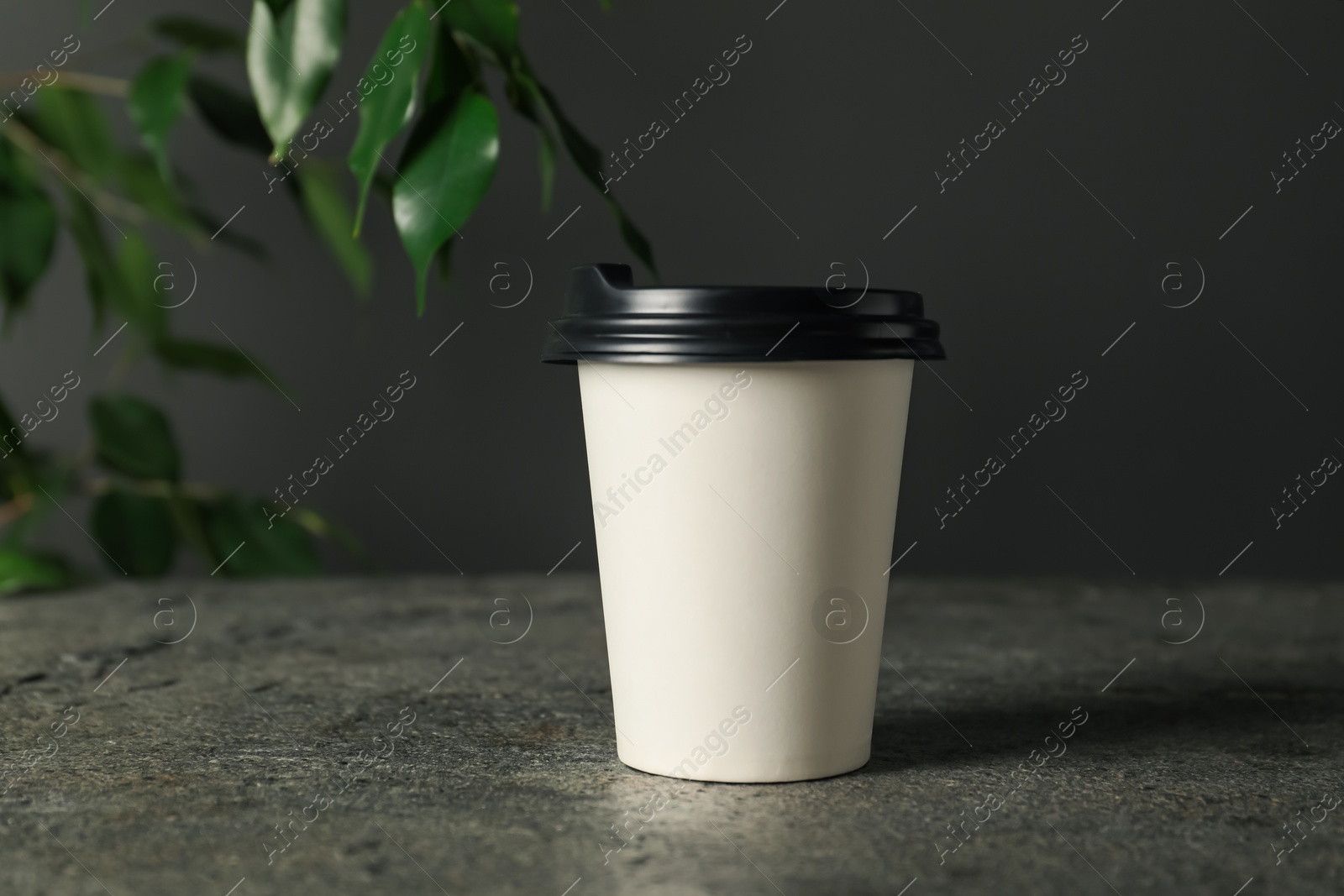 Paper cup on grey textured table indoors, closeup. Mockup for design Photo of Paper cup on grey textured table indoors, closeup. Mockup for design